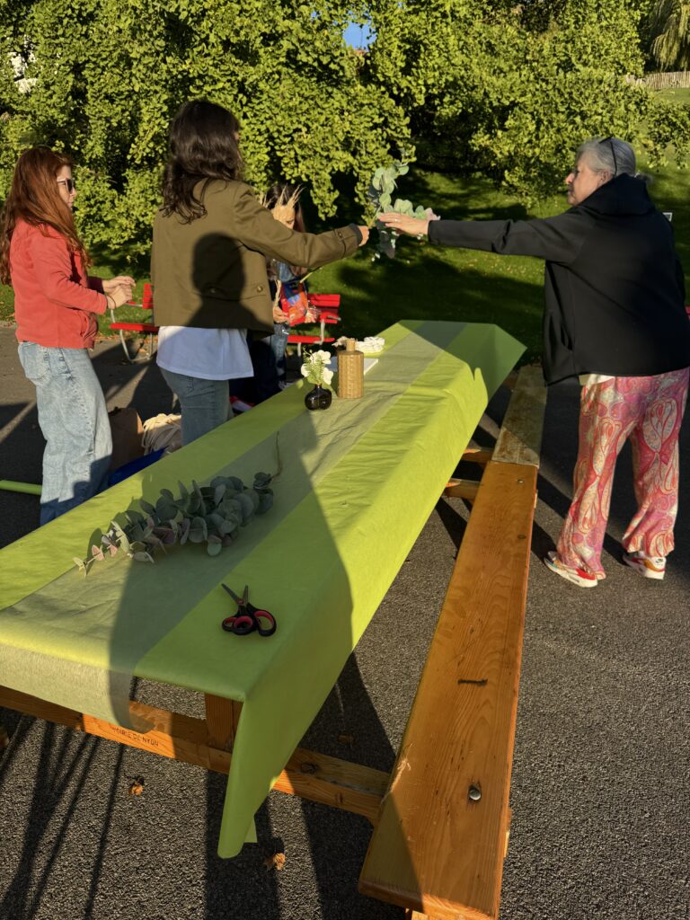 Préparation de la table d’un atelier en plein air, dans un parc arboré.