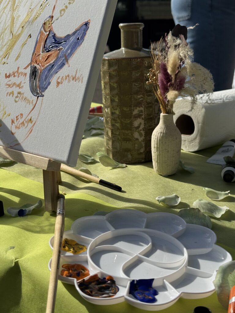 Une palette de peinture et une toile colorée sur la table de l’atelier.