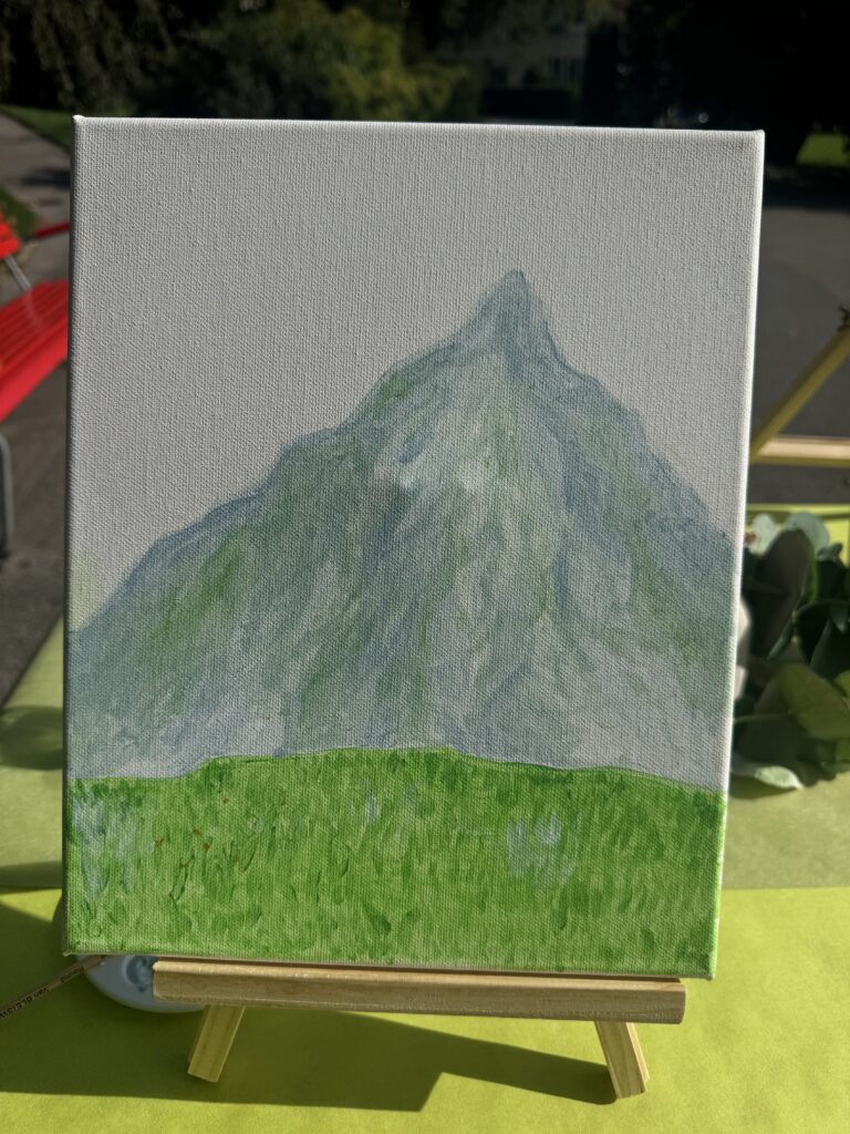 Toile terminée : une montagne au-dessus d’un pré vert.
